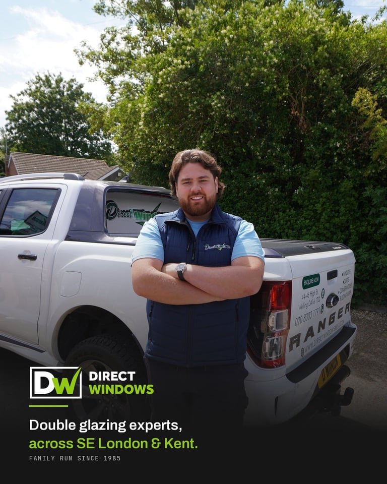 Man in Direct Windows uniform posing with arms crossed next to white service van with trees in background